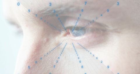 Focusing senior male right eye with biometric grid overlay and numeric iris security scan