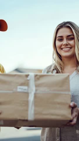 Vertical video of smiling woman receiving delivery box from courier on doorstep