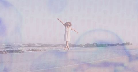 Joyful Woman Strolling Along Scenic Beach at Sunset