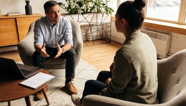 Man consulting woman in modern office during focused one-on-one professional conversation