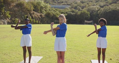 Girls Stretching for Team Sports Training Outdoors