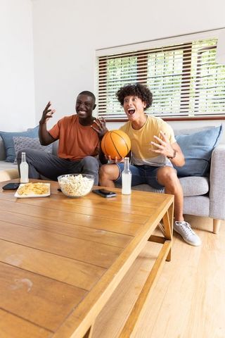 Excited Friends Watching Sports Holding Basketball with Snacks