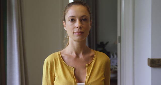 Young Woman Standing Inside Home Wearing Yellow Cardigan - Download Free Stock Images Pikwizard.com