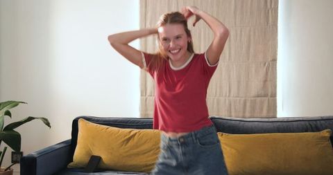 Joyful teen girl dancing happily at home in casual wear