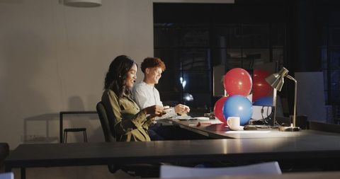Team Celebrating After Hours with Cake and Balloons at Office