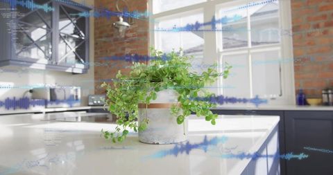 Trailing plant cascading over white kitchen island with brick wall and blue audio waveform