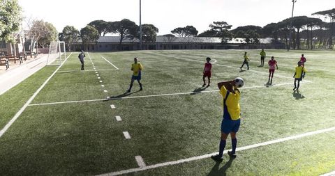 Athletes Practicing Soccer with a Team Throw-In Play