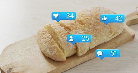 Rustic bread loaf resting on wooden board with social media notification bubbles