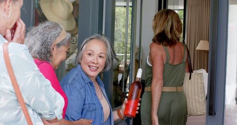 Senior Friends Welcoming with Wine Spill Comfort