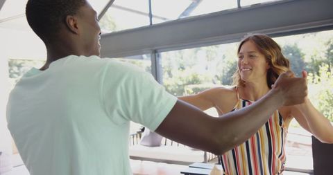 Diverse Couple Enjoying Dance in Sunlit Home Interior