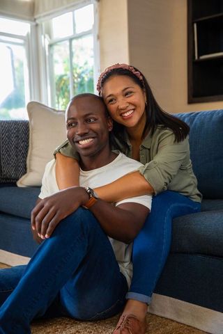 Diverse Couple Sharing Joyful Moment on Living Room Sofa