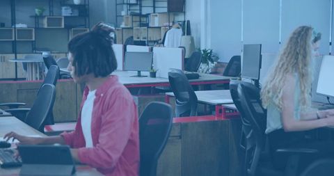 Young professionals working in modern open office using tablets and collaborative desks