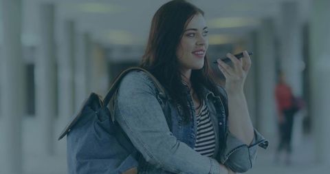 Young Woman Using Smartphone Microphone in Urban Transit Environment