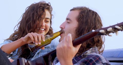 Young Couple Enjoying Music and Drinks Together Outdoors