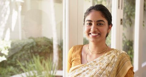 Smiling woman in traditional sari by window