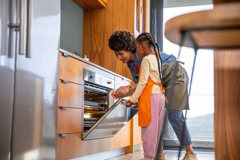 Mother and daughter baking time together in modern kitchen
