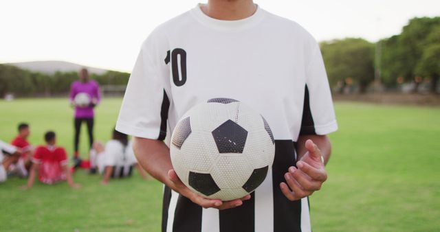 Image of biracial football player on field with ball. Male football team, inclusivity and fitness in team sports.
