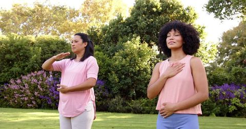 Mother and Daughter Meditating Together Outdoors in Park