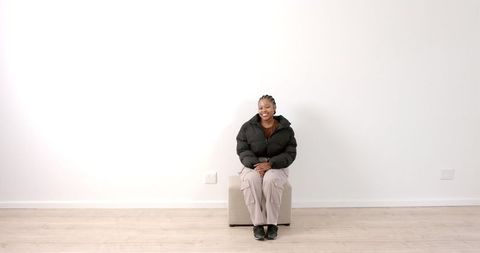 African American Woman Relaxing on Ottoman in Minimalist Interior - Download Free Stock Images Pikwizard.com