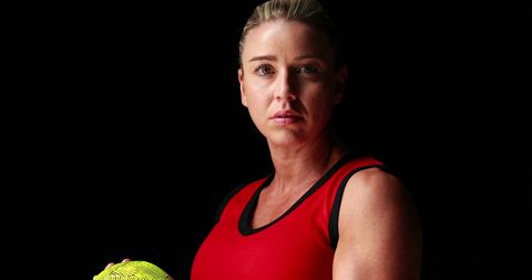 Focused Sportswoman Holding Ball on Black Background