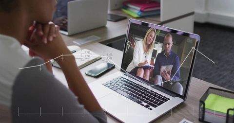 Remote collaboration on laptop showing colleagues in video call with notes and analytics overlay