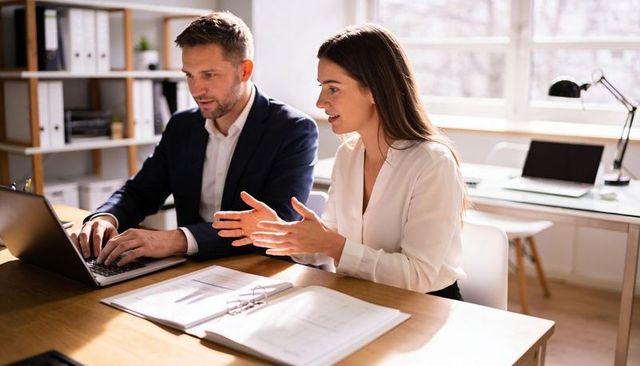 Professionals reviewing documents and collaborating at bright modern office table