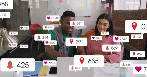 Collaborating Coworkers Pointing at Laptop Showing Social Media Notifications and Analytics