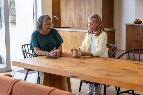 Senior Women Enjoying Coffee and Conversation at Kitchen Table