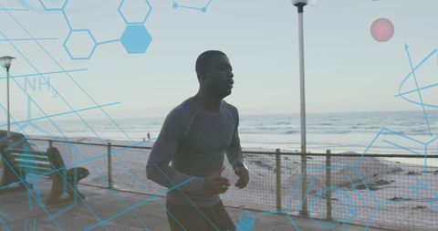 African american man exercising by ocean with data graphics overlay