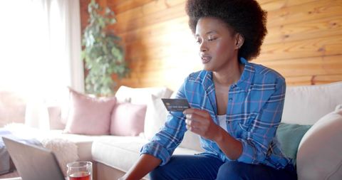 Afro woman shopping online at home with credit card
