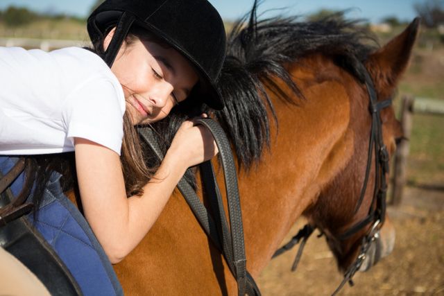 Cute girl embracing horse in the ranch on a sunny day