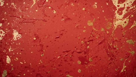 Crimson paint splash with metallic gold flakes and glossy droplets abstract texture
