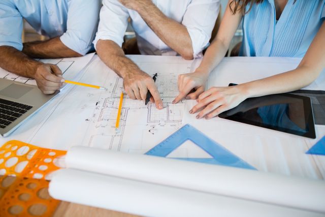 Architects working over blueprint in conference room at office