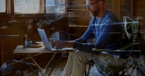 Remote coding in rustic cabin with laptop and futuristic hud overlays for productivity