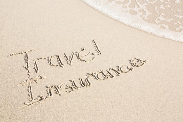 Travel Insurance written on sandy beach near ocean waves. Ideal for travel agencies, insurance companies, vacation planning, and promotional materials emphasizing the importance of travel safety and protection.