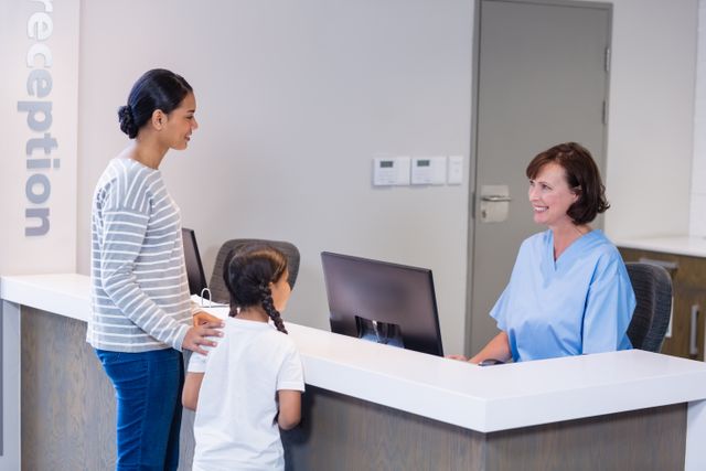 Nurse at hospital reception desk assisting a mother and her daughter. Ideal for illustrating healthcare services, patient-nurse interactions, family healthcare, and customer service in medical settings.