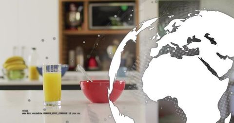Bright kitchen breakfast featuring glass of orange juice and red bowl with globe overlay