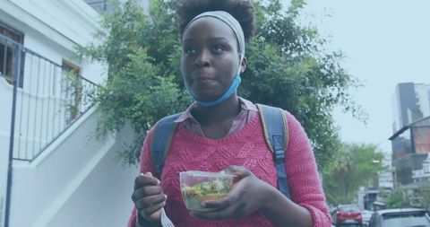 Young woman enjoying healthy snack outdoors in urban setting