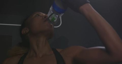 Woman in Gym Drinking Water After Workout