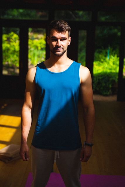Portrait of caucasian young man at yoga studio on sunny day. unaltered, fitness, yoga and healthy lifestyle.