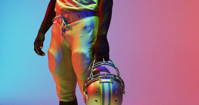 African American football player's midsection is highlighted against a vibrant neon backdrop. - Download Free Stock Photos Pikwizard.com