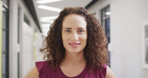 Confident Female Teacher Standing in School Hallway