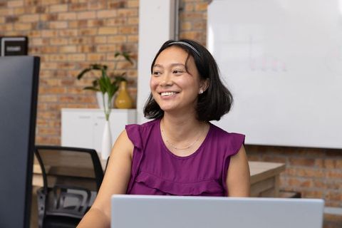 Businesswoman Working at Desk with Modern Office Background
