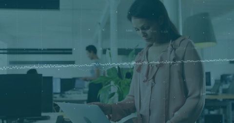 Professional Woman Using Laptop in Modern Open-Plan Office with Plants