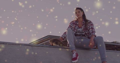 Skateboarder relaxing on ramp with sparkling lights effect