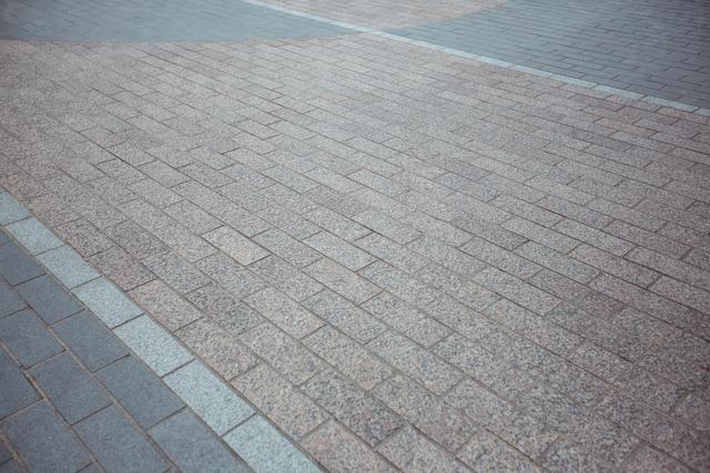 Brick and stone pavement providing an urban texture background. Suitable for use in architectural design, construction, or urban development projects. Ideal for illustrating flooring, walkways, or city infrastructure.