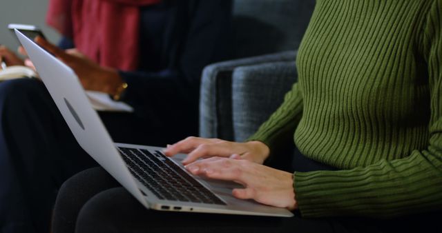 Person Working on Laptop in Cozy Workspace with Colleague - Download Free Stock Images Pikwizard.com