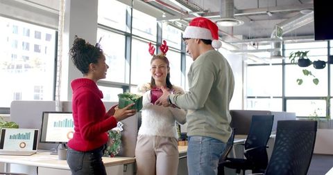 Diverse Coworkers Exchanging Holiday Gifts and Laughing in Bright Open-plan Office
