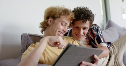 Happy Male Couple Enjoying Tablet on Cozy Sofa - Download Free Stock Images Pikwizard.com