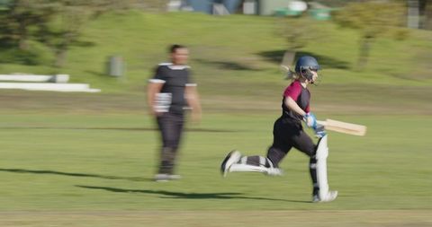 Girl Sprinting on Cricket Field in Protective Gear During Practice